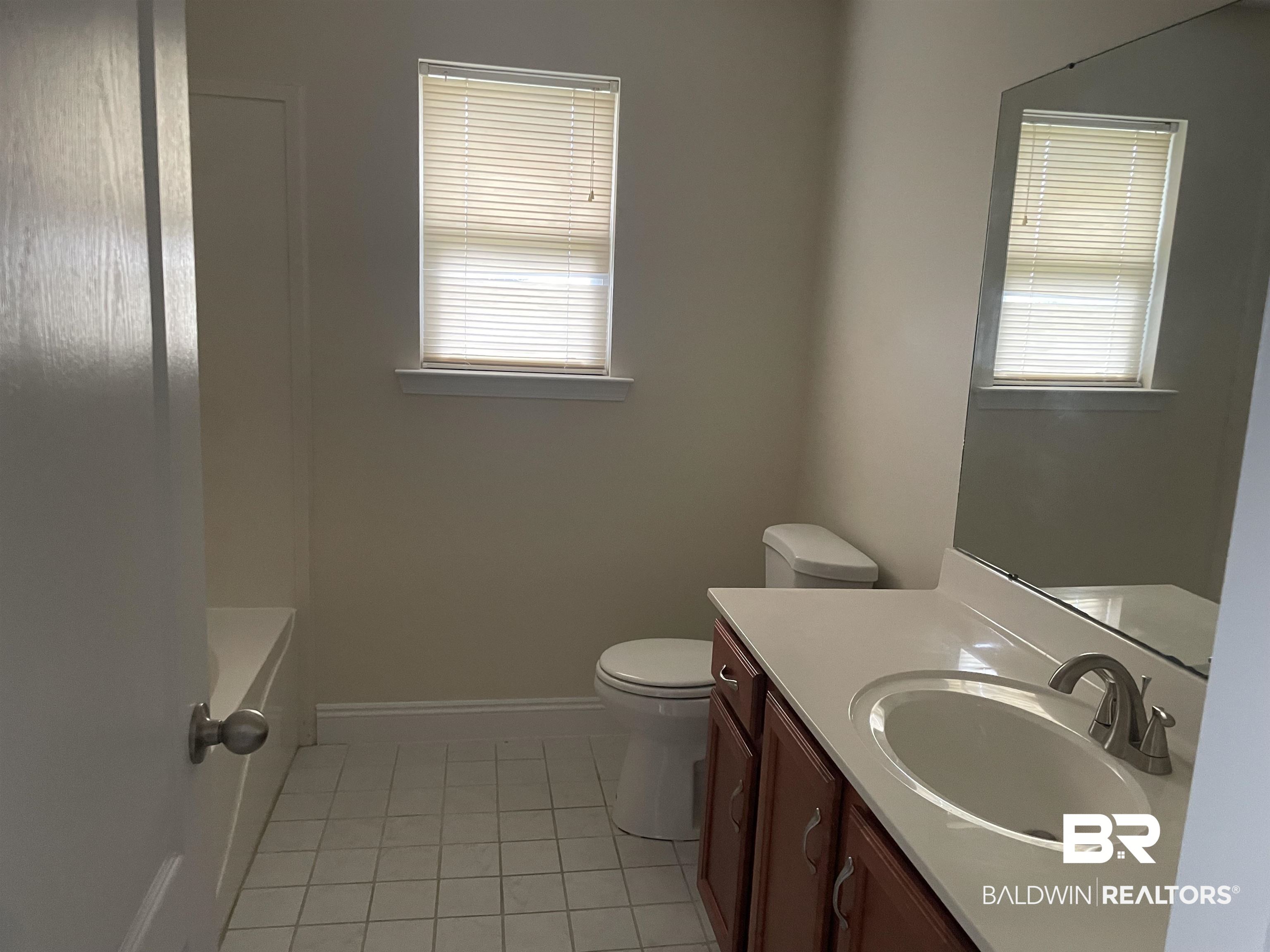 23575 Fountain Street Robertsdale, AL 36567 - Photo 9 of 19 Bathroom with plenty of natural light, vanity, toilet, and baseboards