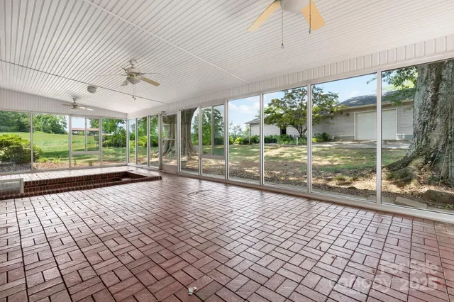 a view of house with a big yard and large trees