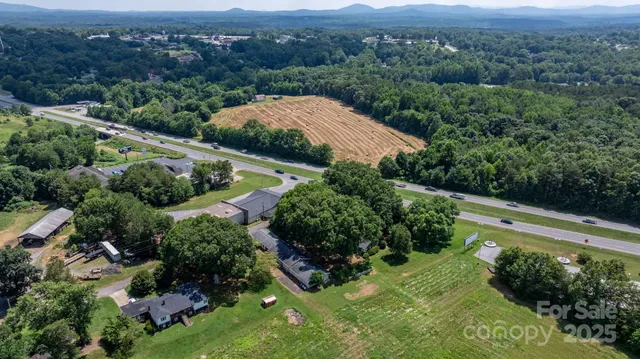an aerial view of residential houses with outdoor space and trees