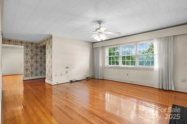wooden floor fireplace and windows in an empty room