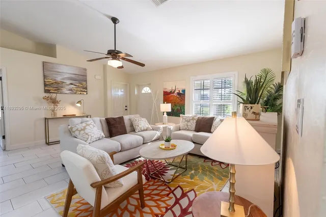a living room with furniture a chandelier and a dining table