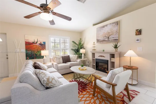 a living room with furniture fireplace and a large window