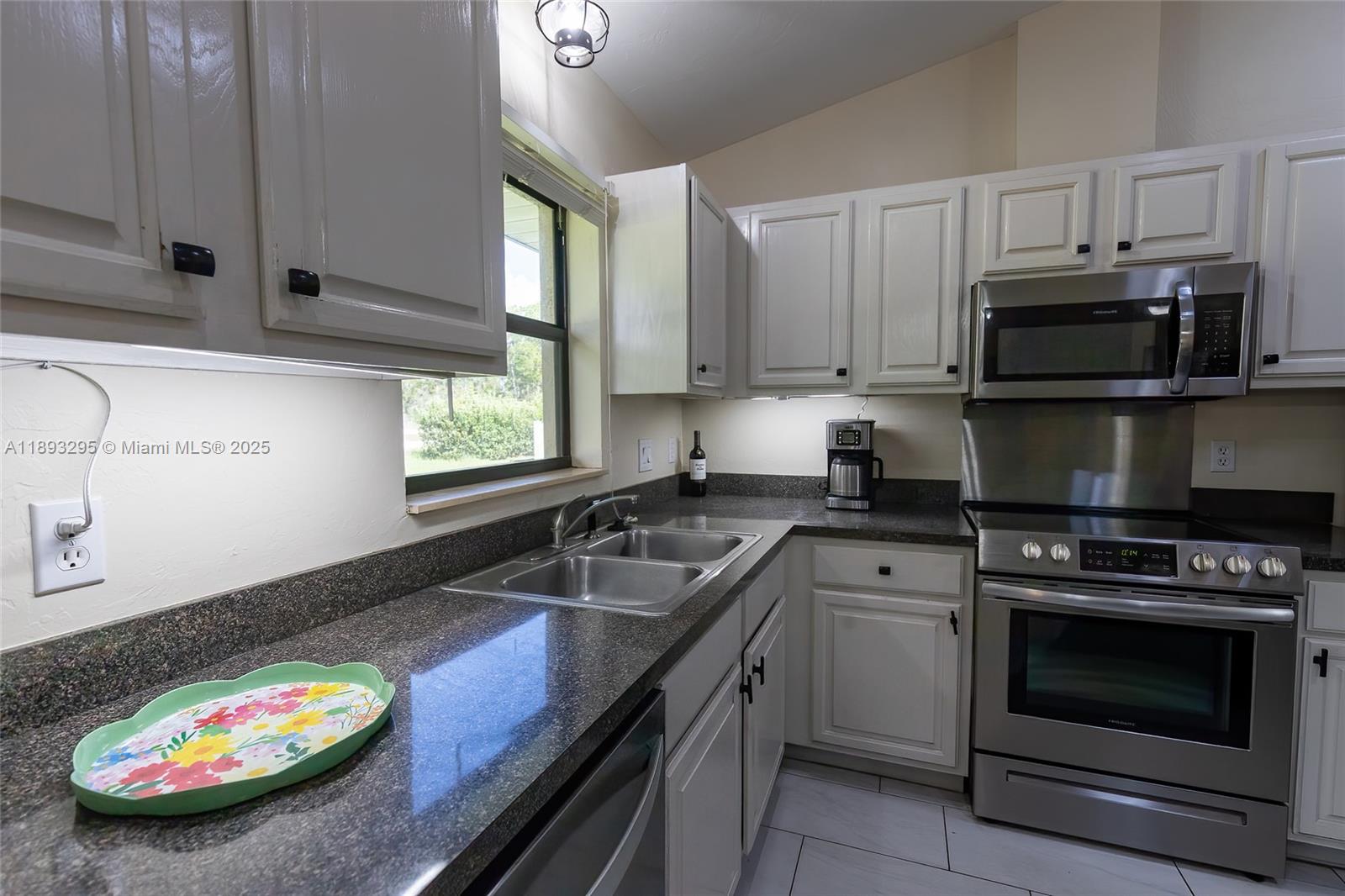 36 Quail Roost Road Lake Placid, FL 33852 - Photo 28 of 48 a kitchen with granite countertop a sink a stove and microwave