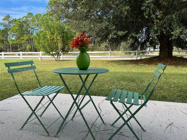 a view of yard with seating area and trees in the background