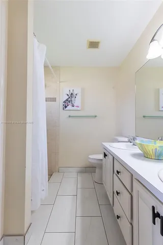 a spacious bathroom with a granite countertop sink a toilet and a mirror