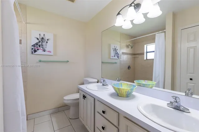 a bathroom with a granite countertop sink a toilet and a mirror