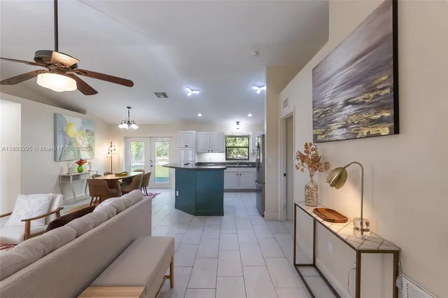 a view of a kitchen with kitchen island stainless steel appliances wooden floor and a chandelier