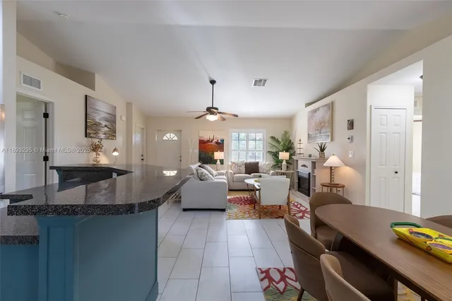 a living room with furniture a chandelier and a dining table