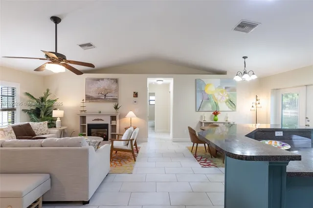 a living room with furniture a chandelier and a fireplace