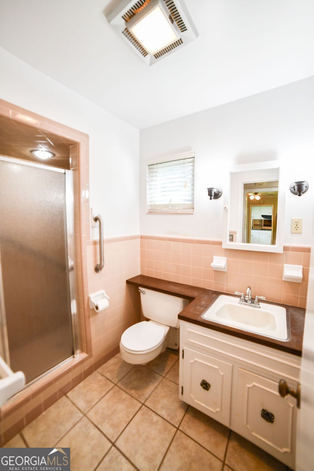 39 Adams Street Jesup, GA 31545 - Photo 42 of 49 a bathroom with a granite countertop sink a toilet a mirror and shower