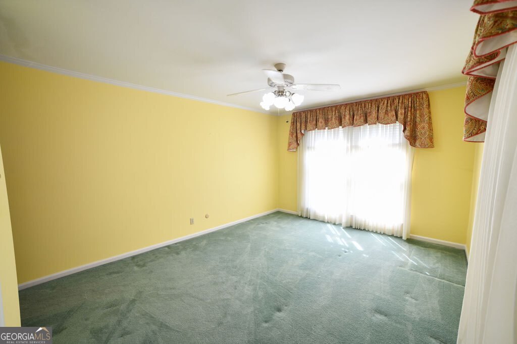 39 Adams Street Jesup, GA 31545 - Photo 44 of 49 an empty room with a chandelier fan and a window