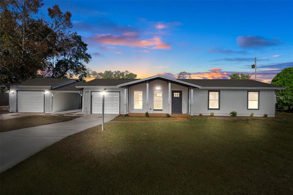 11029 Maderia Street Spring Hill, FL 34608 - Photo 1 of 1 a front view of a house with a garden and yard