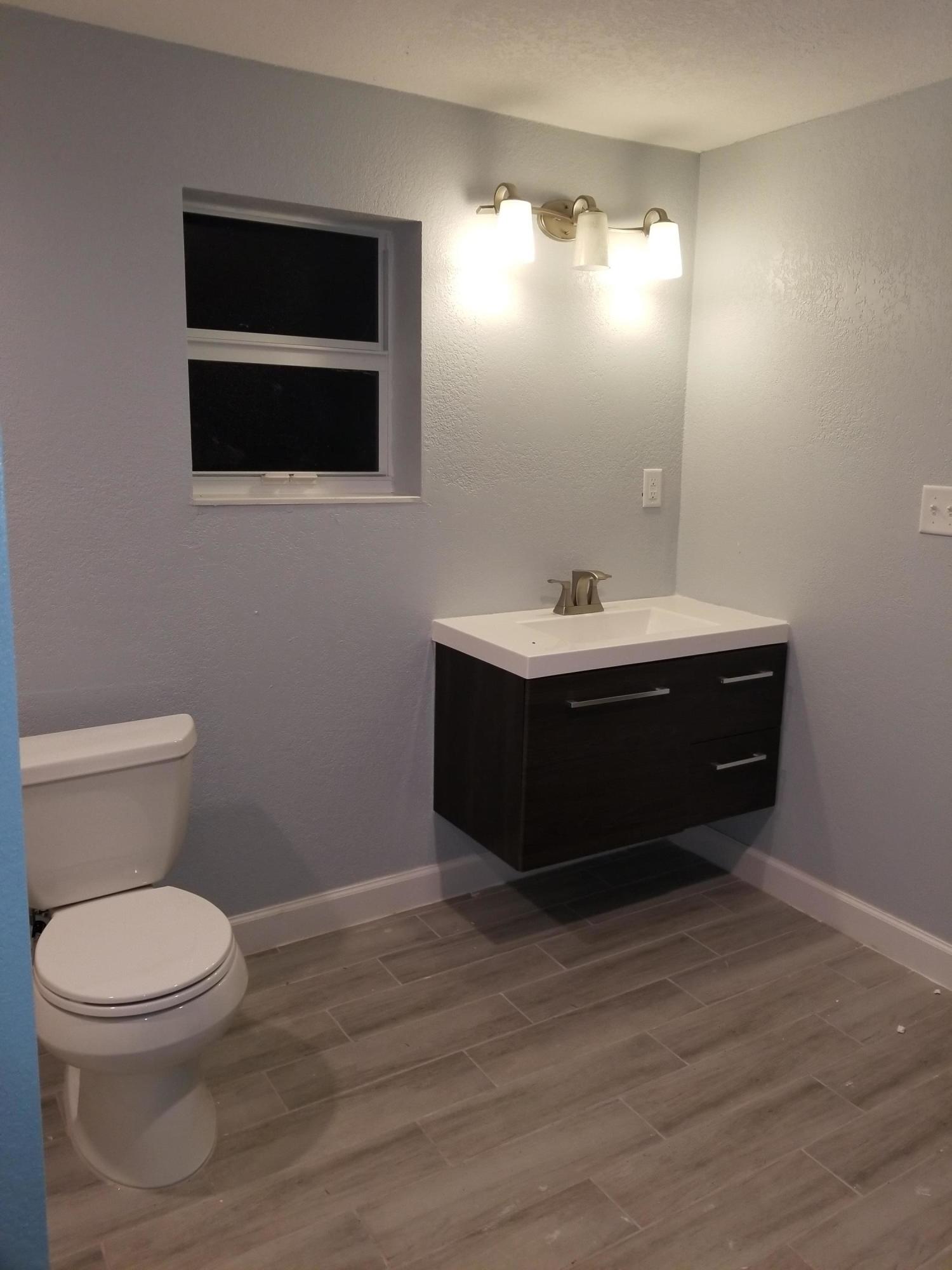 1221 Highview Road Lake Worth, FL 33462 - Photo 12 of 20 a bathroom with a toilet a sink and mirror
