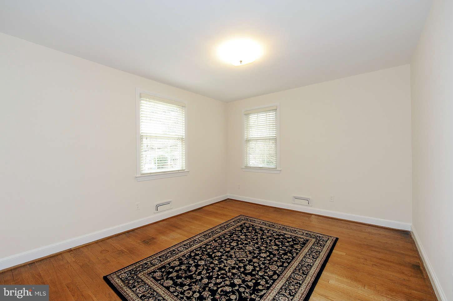 5719 Ogden Road Bethesda, MD 20816 - Photo 15 of 22 an empty room with wooden floor and windows