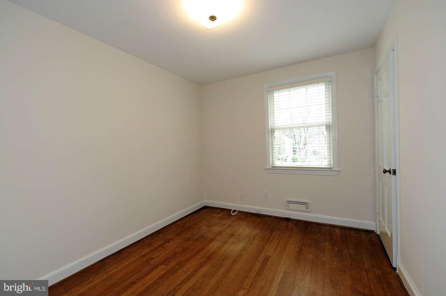 5719 Ogden Road Bethesda, MD 20816 - Photo 16 of 22 an empty room with wooden floor and windows