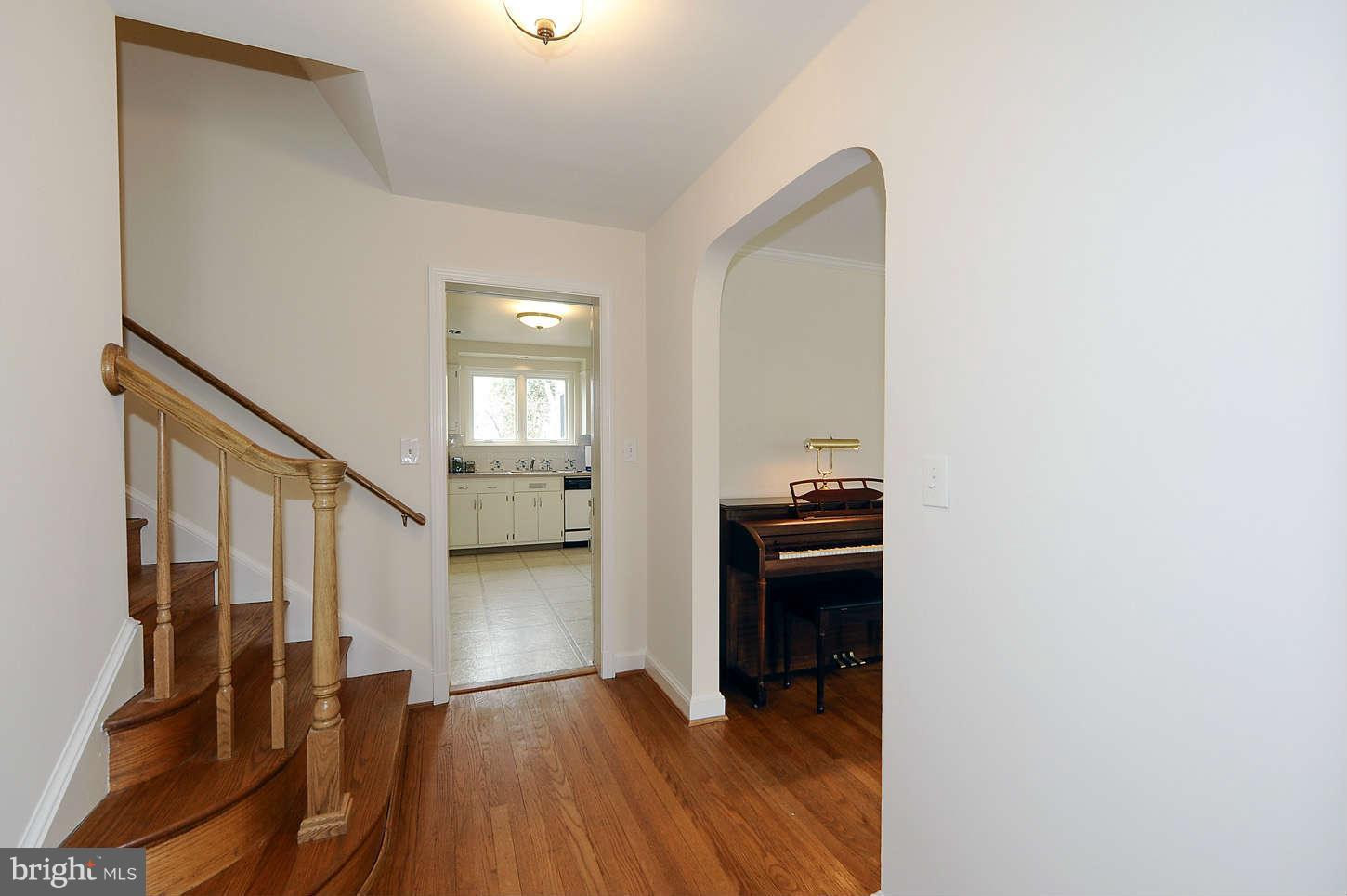 5719 Ogden Road Bethesda, MD 20816 - Photo 6 of 22 a view of a hallway to an empty room with wooden floor and a window