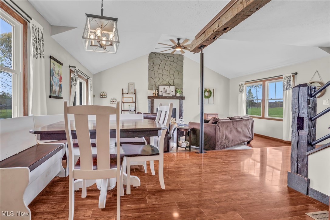 39233 Jones Road Litchfield, OH 44253 - Photo 10 of 46 Dining room featuring baseboards, vaulted ceiling with beams, ceiling fan with notable chandelier, and wood finished floors
