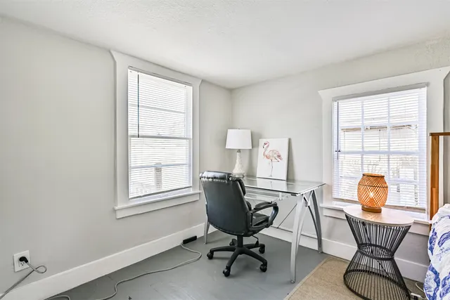 a view of a workspace with furniture and a window