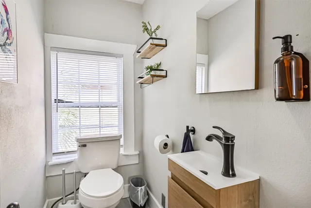 a bathroom with a sink a toilet and a window