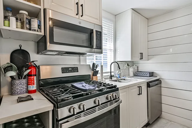 a stove top oven sitting inside of a kitchen