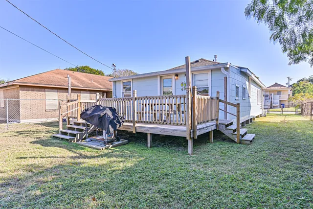 a view of a chair and table in backyard of the house