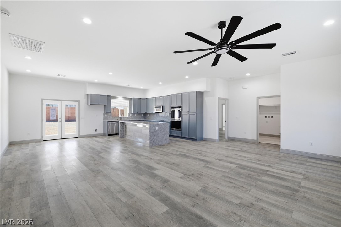1061 Factory Road Pahrump, NV 89048 - Photo 7 of 41 An open concept living space features a modern kitchen, durable wood flooring, and double patio doors.