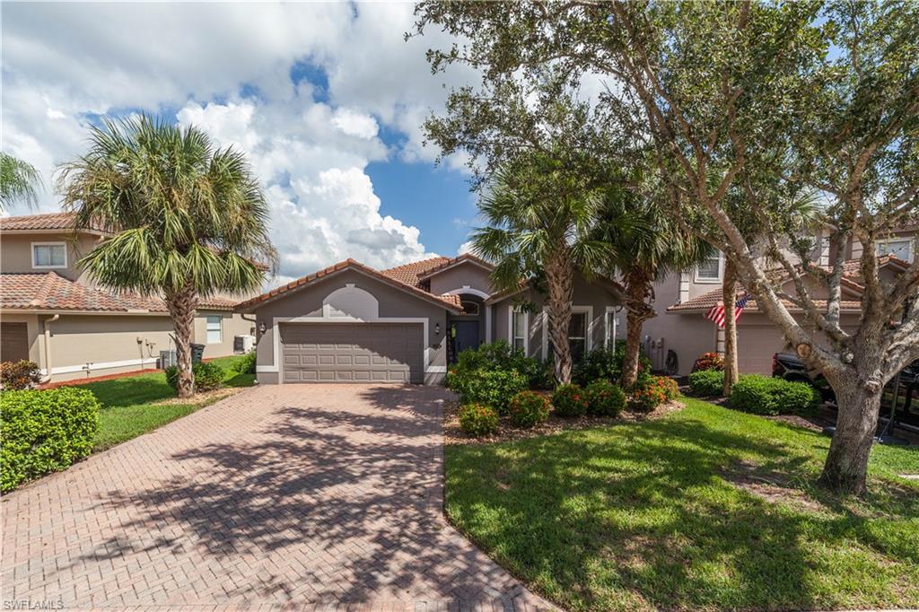 a front view of a house with a yard and large trees