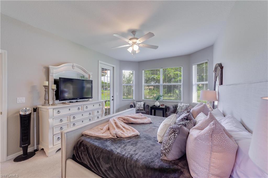 20599 Ardore Lane Estero, FL 33928 - Photo 22 of 34 a bedroom with a bed and a flat screen tv