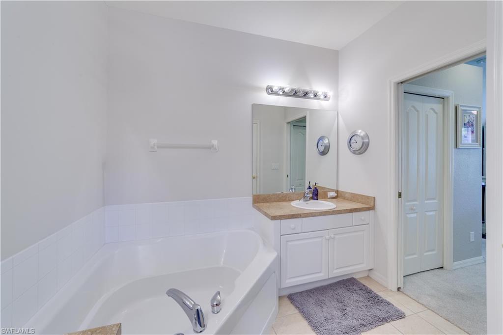 20599 Ardore Lane Estero, FL 33928 - Photo 23 of 34 a bathroom with a tub sink and mirror