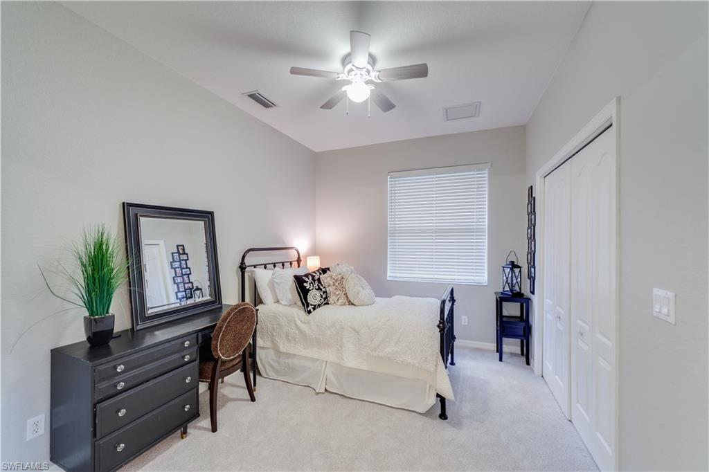 20599 Ardore Lane Estero, FL 33928 - Photo 28 of 34 a bedroom with furniture and a chandelier