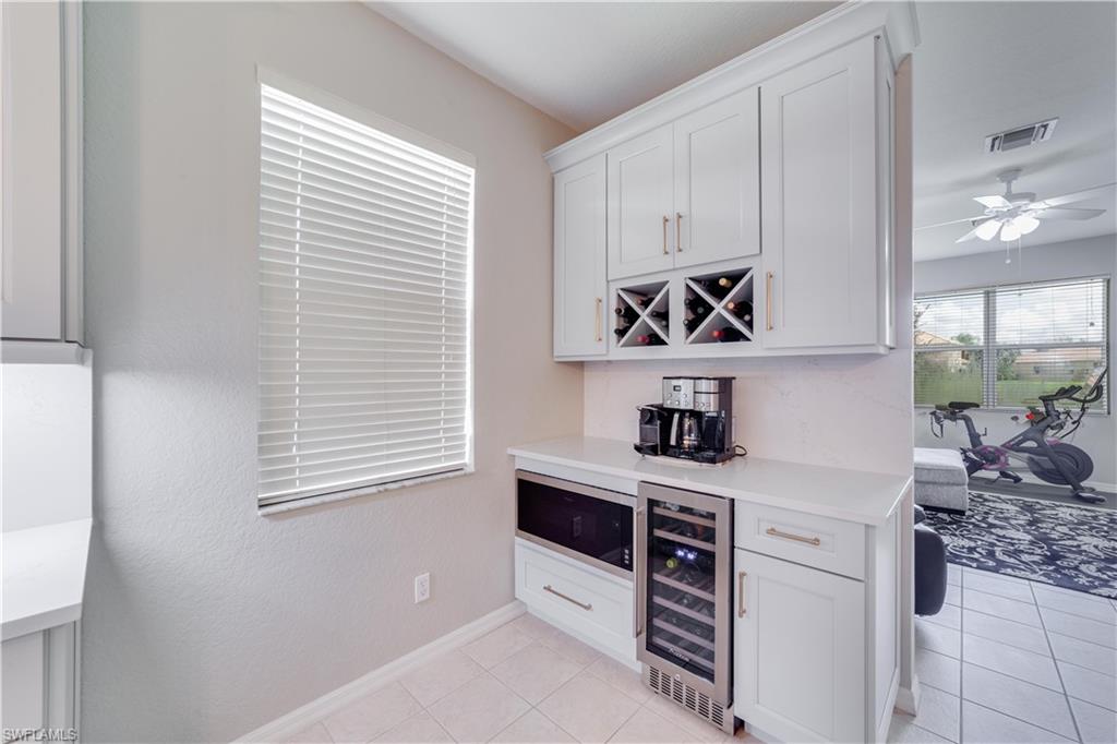 20599 Ardore Lane Estero, FL 33928 - Photo 29 of 34 a kitchen with stainless steel appliances white cabinets and a window