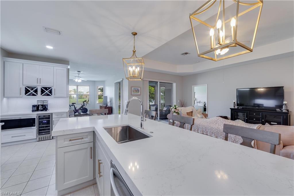 20599 Ardore Lane Estero, FL 33928 - Photo 6 of 34 a kitchen with stainless steel appliances a stove a sink and a refrigerator