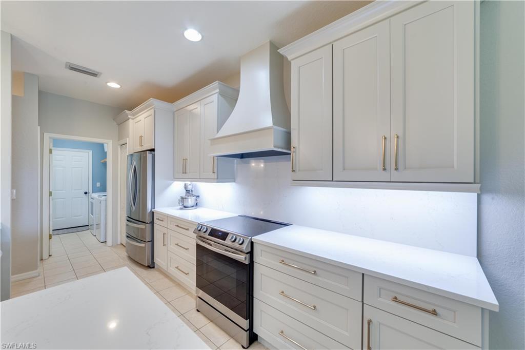 20599 Ardore Lane Estero, FL 33928 - Photo 8 of 34 a kitchen with stainless steel appliances granite countertop a sink and a stove