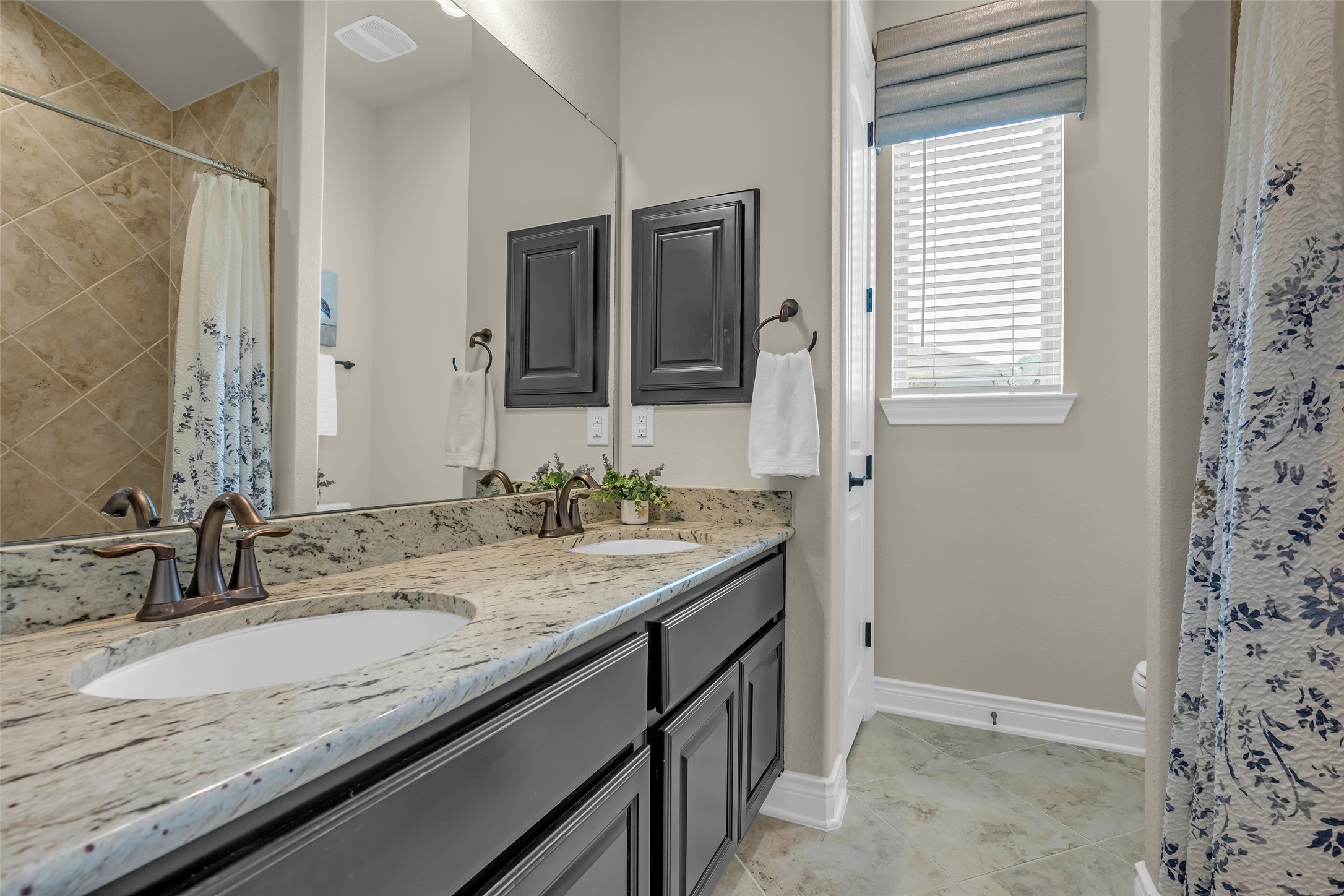 14003 South Evergreen Ridge Court Conroe, TX 77384 - Photo 28 of 43 Double sinks, granite countertops, and a tiled tub/shower serve the two secondary bedrooms.