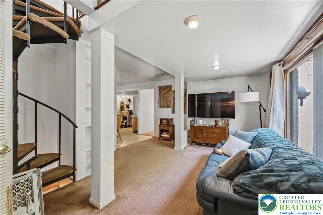 5340 2nd Street Whitehall, PA 18052 - Photo 14 of 30 A spacious recreation room featuring a spiral staircase and plush carpeting.