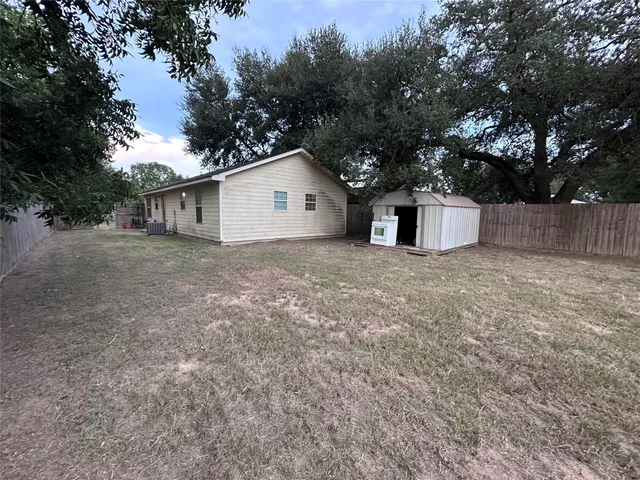 a view of a house with a yard and large tree