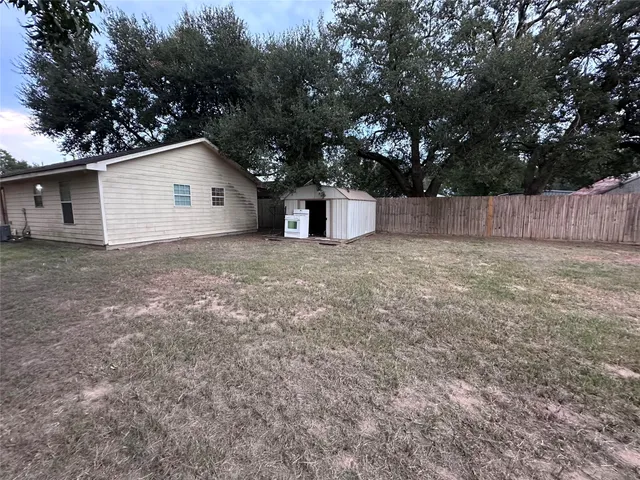 a view of a house with a yard and large tree