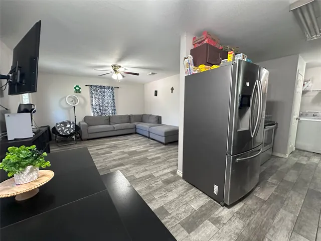 a kitchen with stainless steel appliances kitchen island granite countertop a refrigerator and a stove