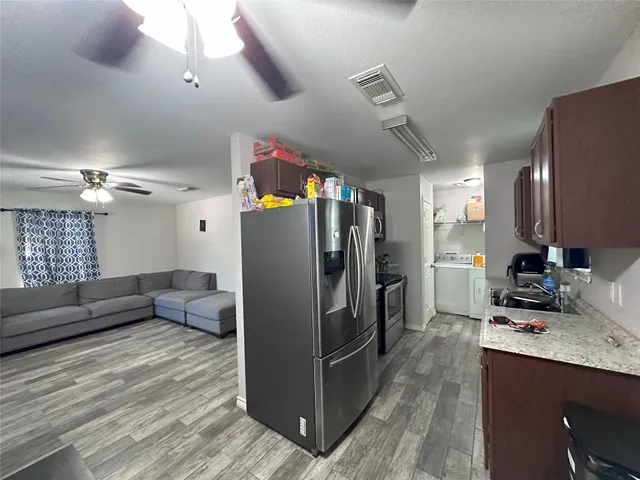 a kitchen with granite countertop a refrigerator a stove and a sink