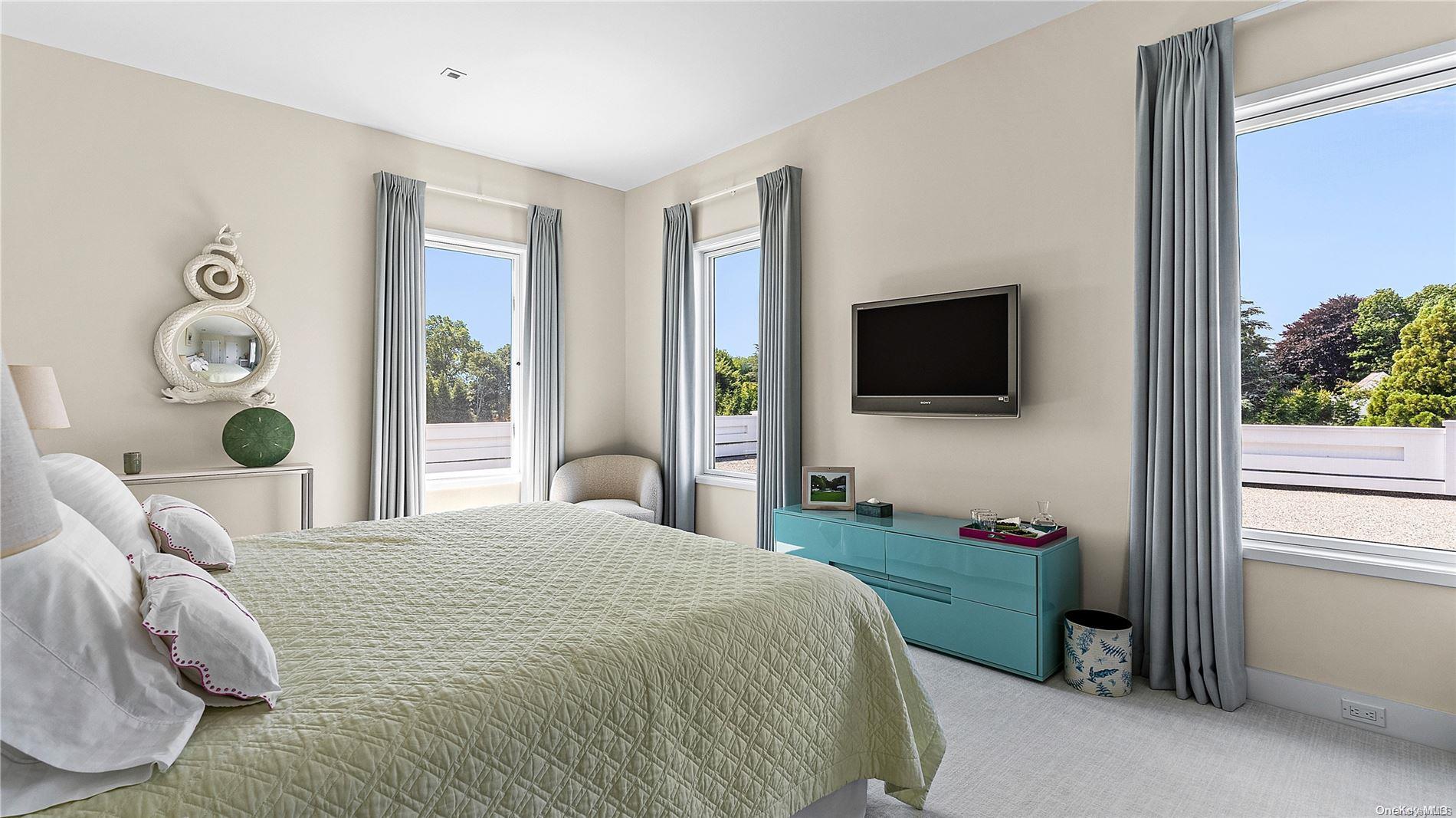 Undisclosed Address Southampton, NY 11968 - Photo 12 of 12 a bedroom with a bed and flat tv screen on the dresser