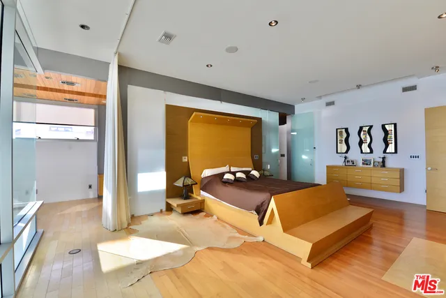 a bedroom with a bed and wooden floor