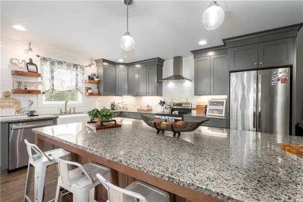a kitchen with granite countertop a sink and cabinets