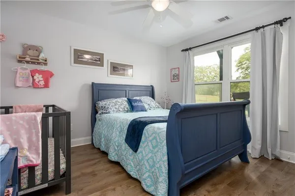 a bedroom with a bed window and a flat screen tv