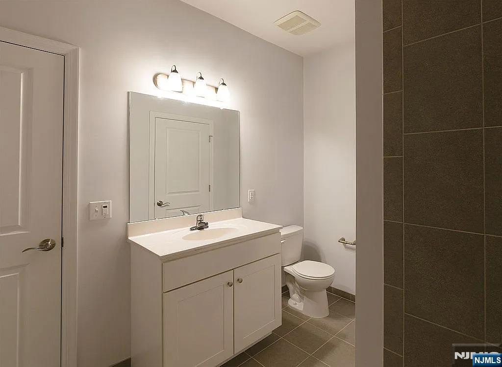 7 Myrtle Street, Unit 10 Bloomfield, NJ 07003 - Photo 12 of 13 a bathroom with a toilet sink and mirror