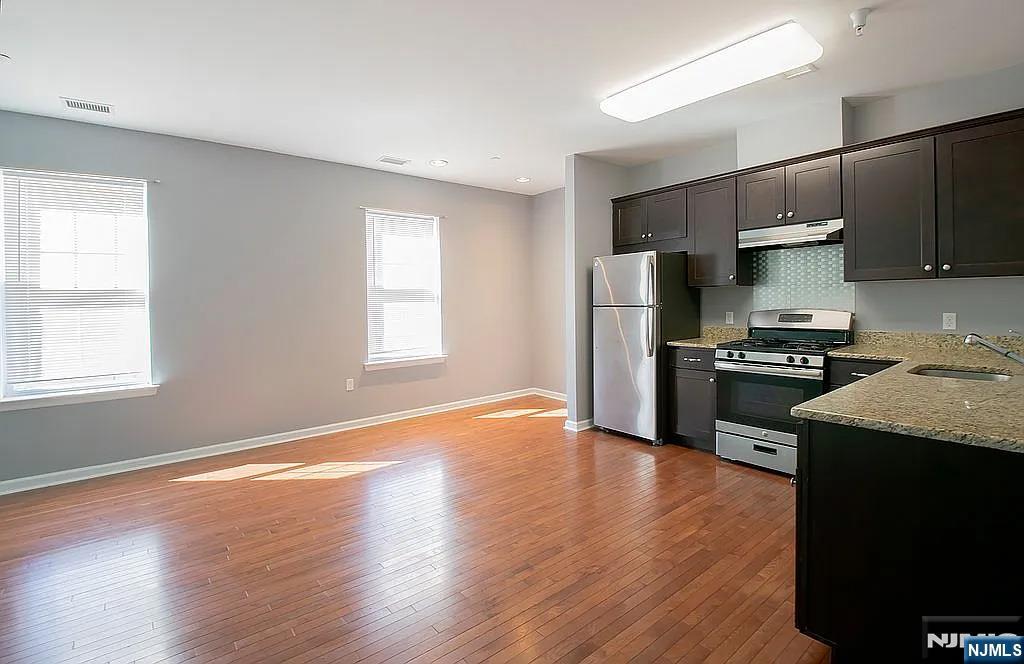 7 Myrtle Street, Unit 10 Bloomfield, NJ 07003 - Photo 3 of 13 a kitchen with granite countertop a refrigerator stove and wooden floor