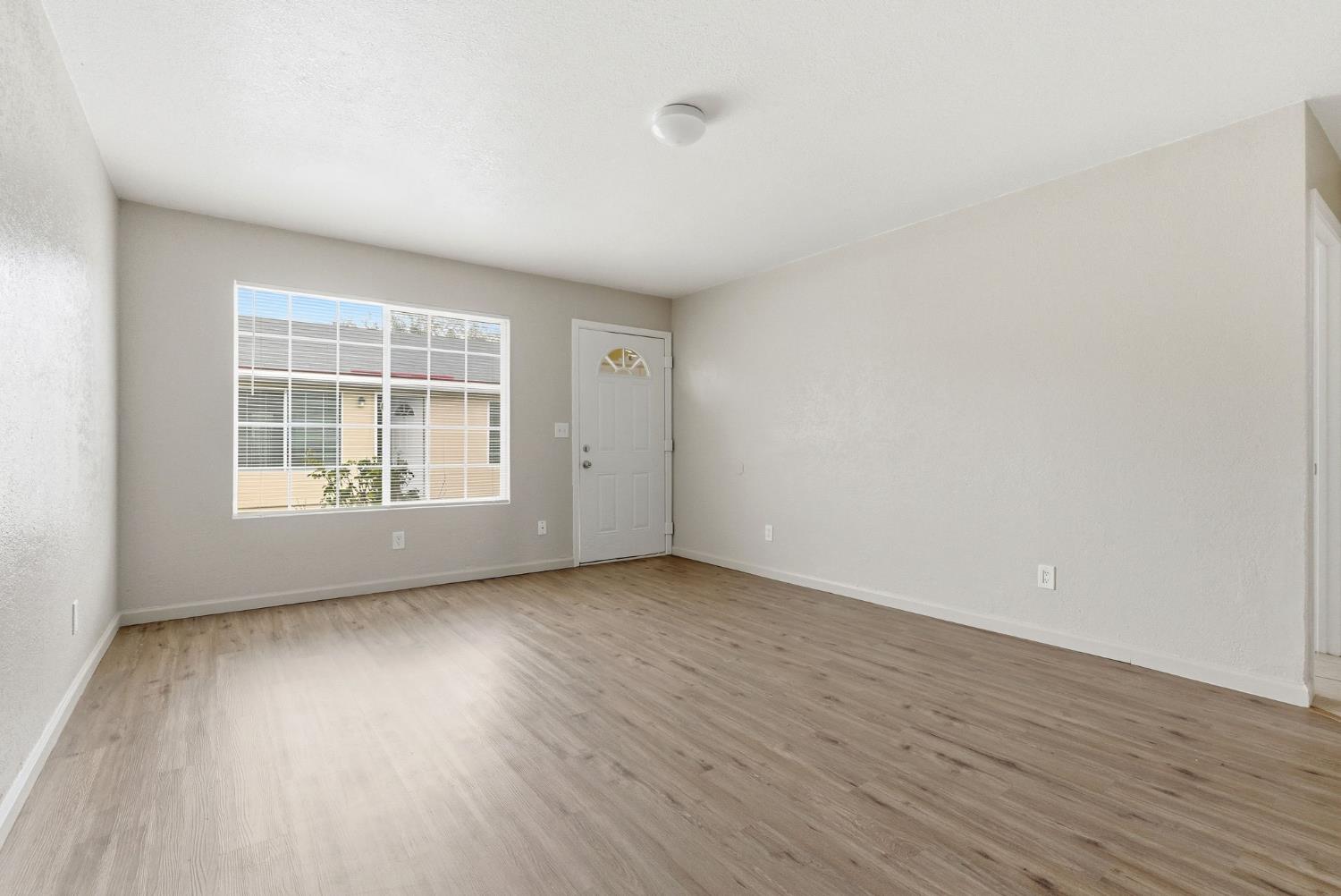 616 South Irwin Street, Unit C Hanford, CA 93230 - Photo 9 of 26 an empty room with wooden floor and windows
