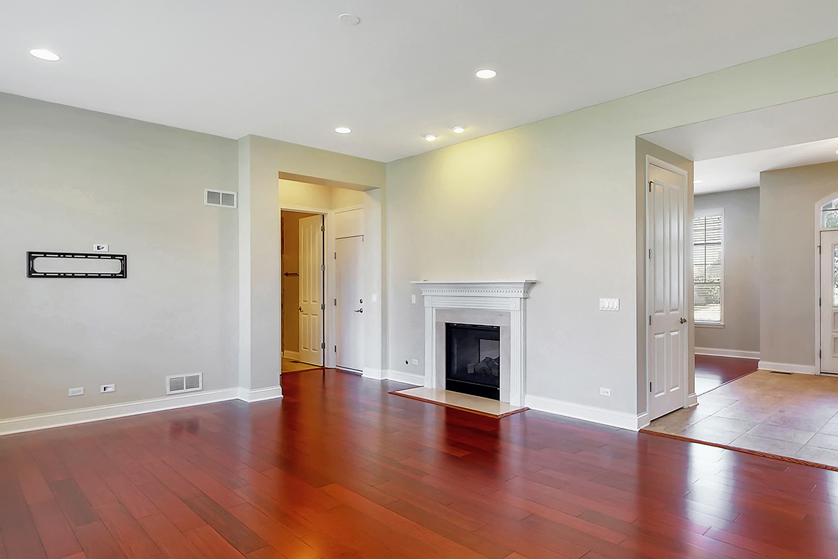 1118 Ashley Lane Inverness, IL 60010 - Photo 15 of 50 a view of an empty room with wooden floor and a fireplace
