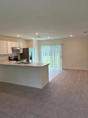 a view of kitchen with kitchen island and stainless steel appliances