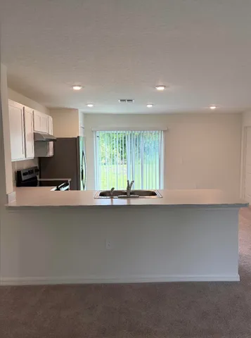 a kitchen with stainless steel appliances granite countertop a sink a stove and a refrigerator