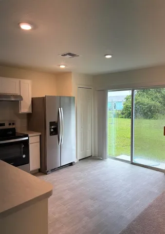a view of an empty room with a kitchen